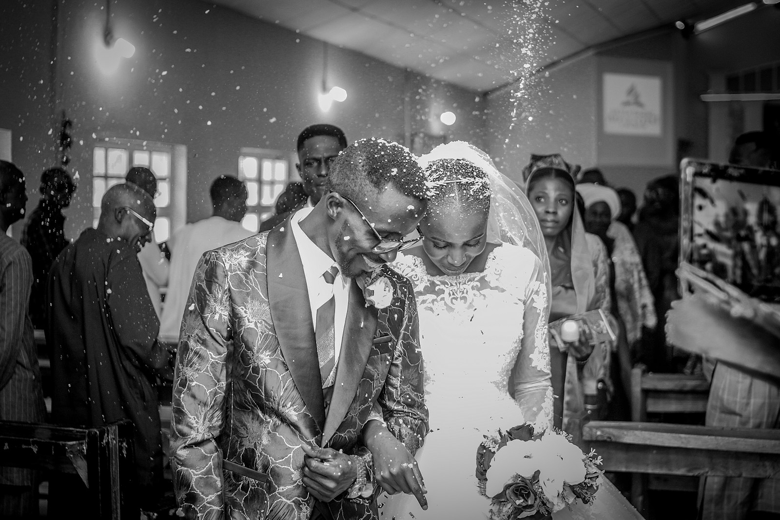 A bride and groom kissing in front of a crowd of people