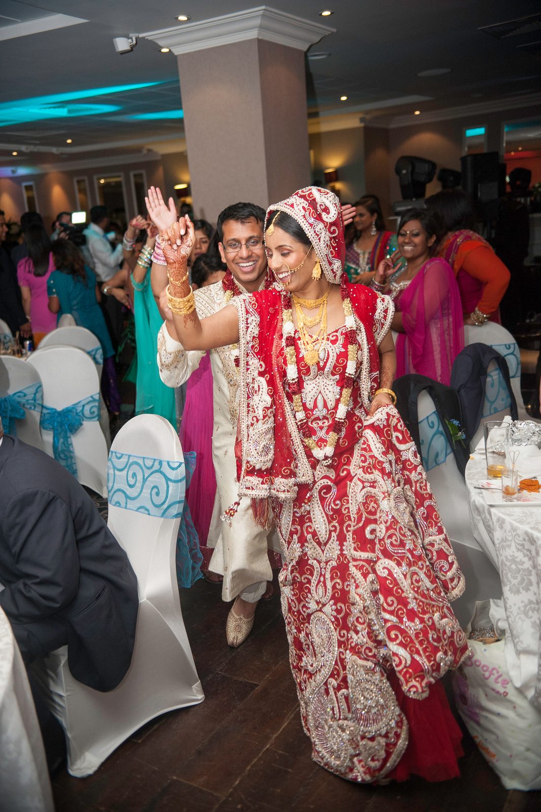 The bride dancing with guests in the middle of the floor at an Asian wedding reception