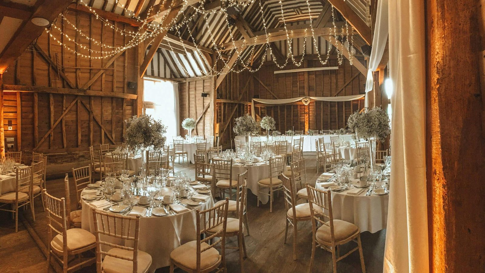 The timber framed Tythe Barn at Tewinbury near Welwyn Garden City, laid with round tables for a wedding